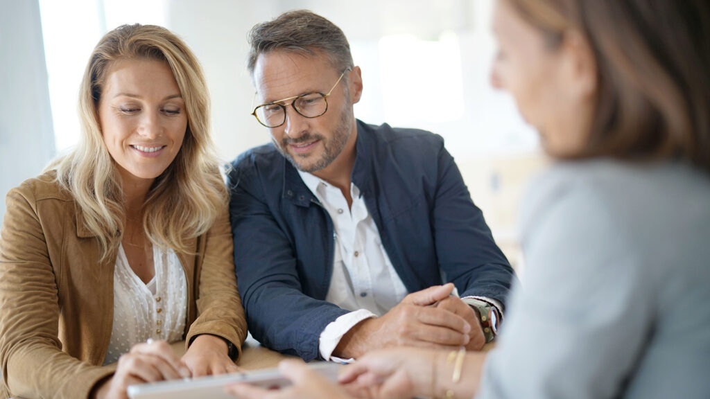 Couple meeting with real estate agent in office.