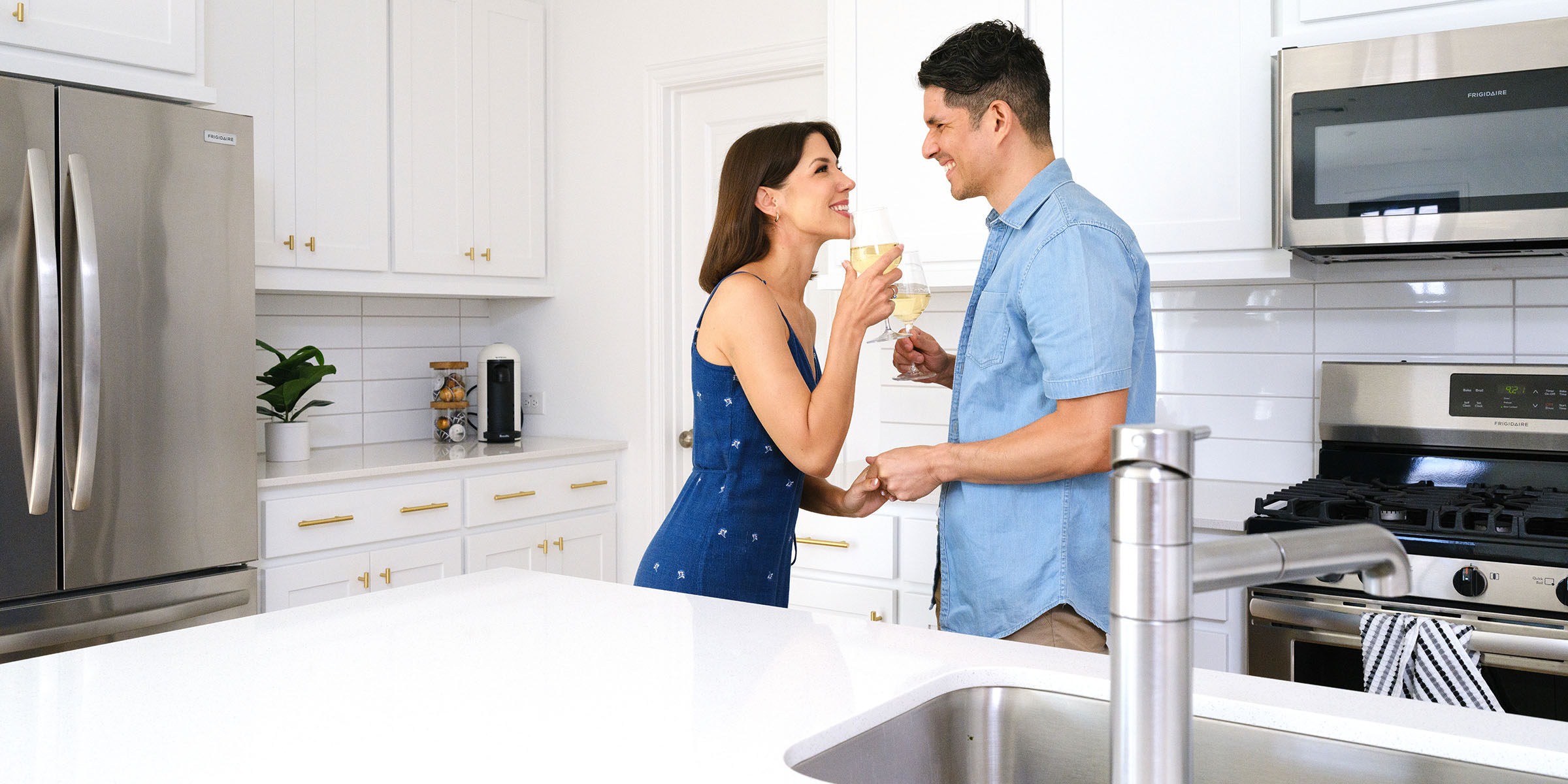 Man and woman drinking wine in a CB JENI townhome kitchen.